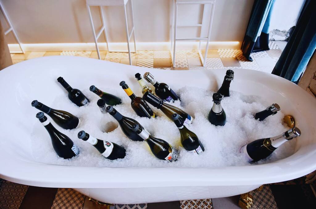 botellas de vino tinto frío en bañera llena de hielo